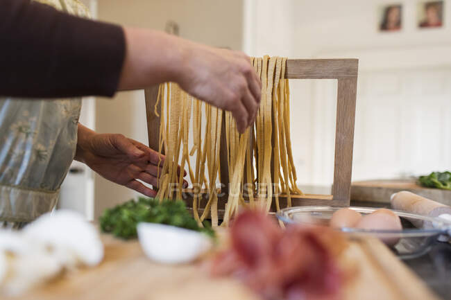 Donna che fa pasta fresca fatta in casa in cucina — Foto stock