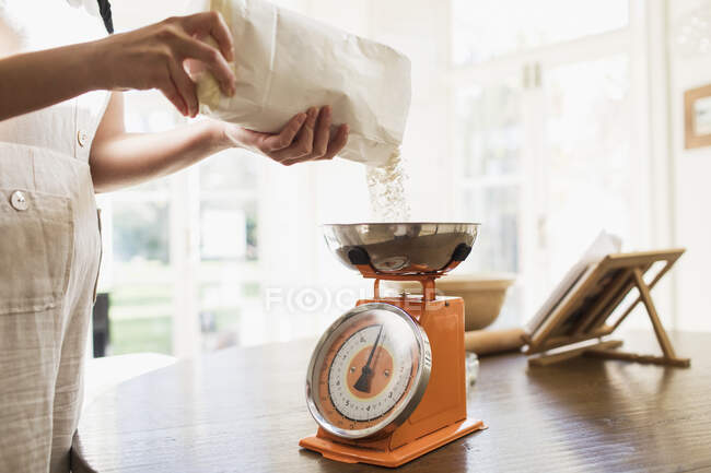 Frau misst Mehl zum Backen in Küche — Stockfoto