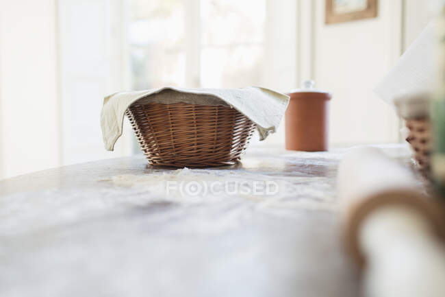 Pane lievitazione in cesto sul bancone della cucina — Foto stock