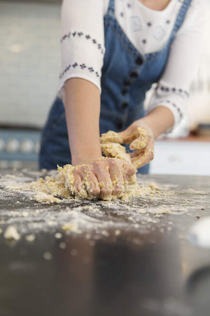Девочка-подросток смешивает тесто на кухонном столе — стоковое фото