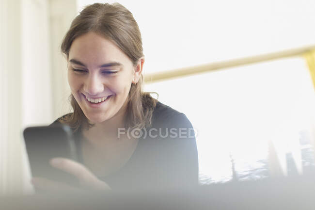 Happy teenage girl using smart phone — Stock Photo