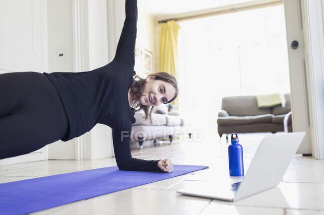 Ragazza adolescente che pratica yoga online a casa — Foto stock
