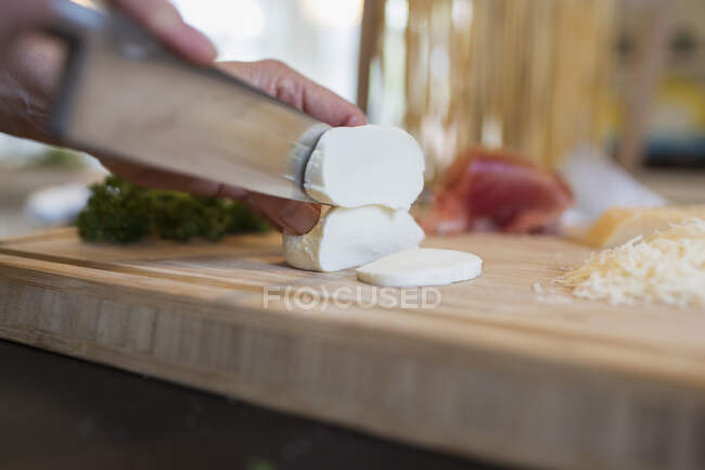 Fechar faca corte em queijo mozzarella fresco — Fotografia de Stock
