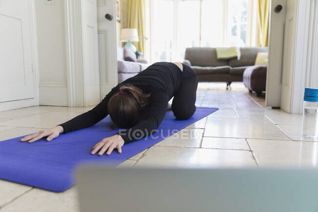 Femme pratiquant le yoga en ligne à la maison — Photo de stock