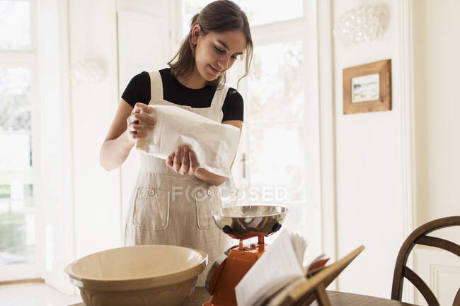 Donna che misura la farina per la cottura in cucina — Foto stock