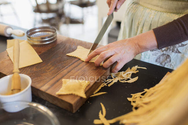 Close up donna taglio pasta fresca fatta in casa — Foto stock