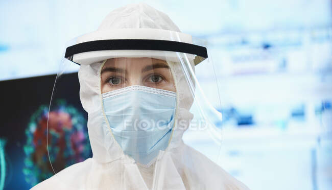 Portrait confident female scientist in clean suit studying coronavirus — Stock Photo