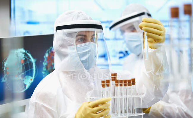 Вчені в чистих костюмах досліджують вакцину проти коронавірусу. — стокове фото