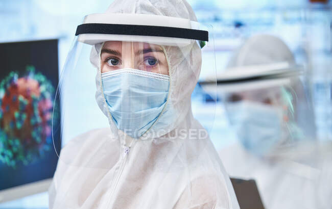 Porträt selbstbewusste Wissenschaftlerin im sauberen Anzug beim Studium des Coronavirus — Stockfoto