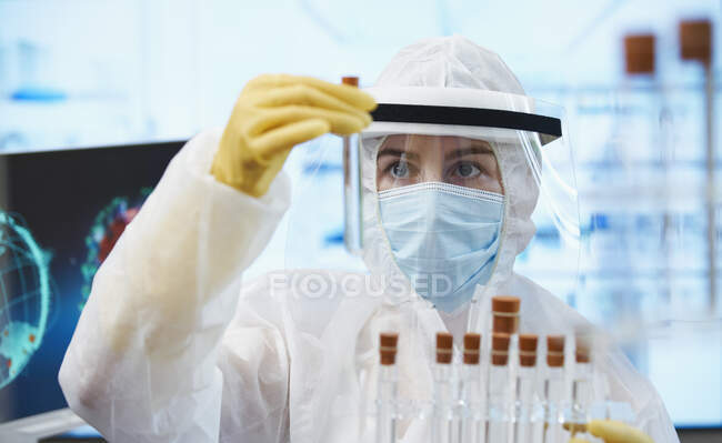Female scientist in clean suit researching coronavirus vaccine — Stock Photo