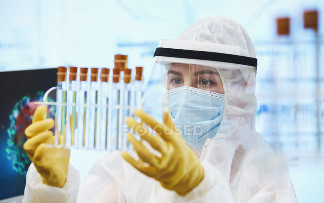 Cientista feminina com tubos de ensaio a pesquisar a vacina contra o coronavírus — Fotografia de Stock