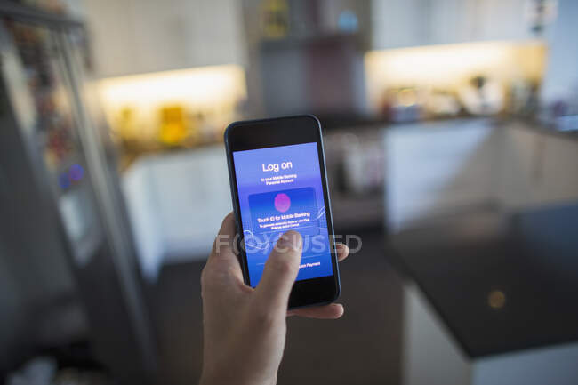 POV Man using touch ID on smart phone in kitchen — Stock Photo