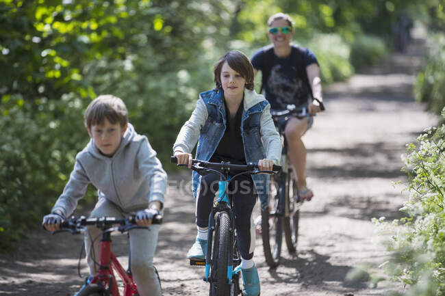 Mother and sons enjoying bike ride on sunny path — Stock Photo