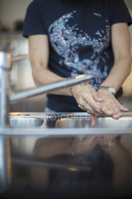 Frau wäscht sich an Spüle die Hände — Stockfoto