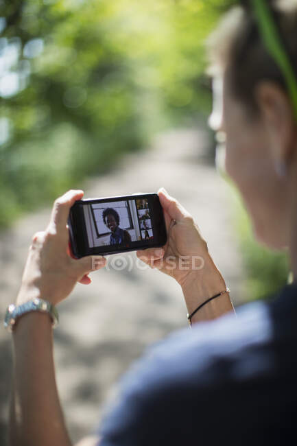Woman video chatting with friends on smart phone screen — Stock Photo
