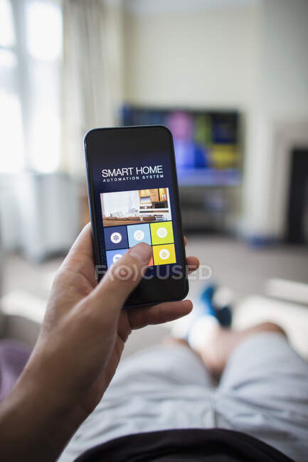 POV Mann nutzt Hausautomation auf Smartphone im Wohnzimmer — Stockfoto