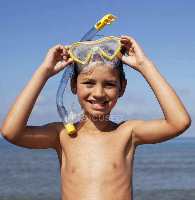 Sonriente chico quitando snorkel y gafas - foto de stock
