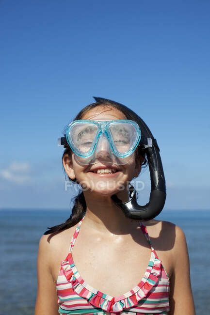 Menina feliz vestindo snorkel e óculos na praia — Fotografia de Stock