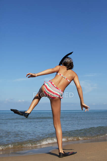 Chica caminando en la playa con aletas - foto de stock