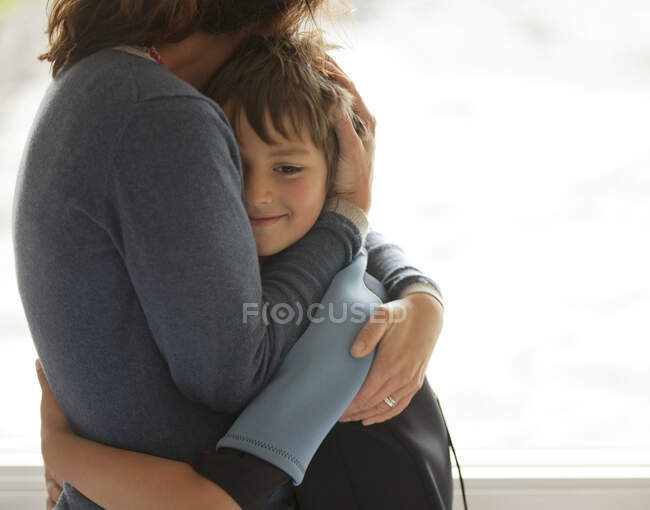 Madre e hijo abrazando - foto de stock