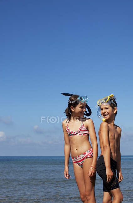 Улыбающиеся брат и сестра на пляже — стоковое фото