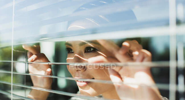 Imprenditrice sbirciando attraverso le tende delle finestre — Foto stock