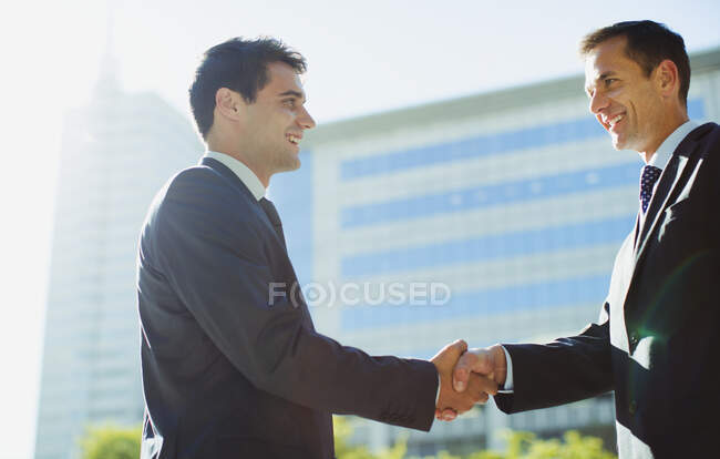 Sorridenti uomini d'affari che stringono la mano fuori Highrise — Foto stock