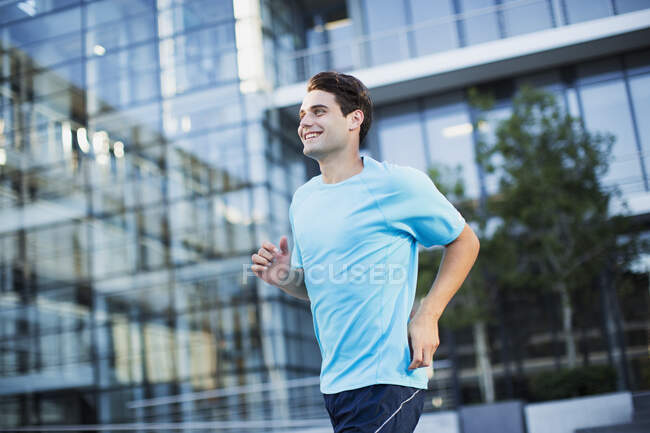 Hombre corriendo fuera del edificio urbano - foto de stock