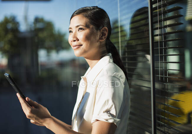 Femme d'affaires souriante utilisant une tablette numérique à l'extérieur — Photo de stock