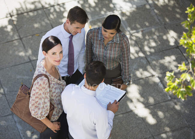 Smiling businesswoman meeting with colleagues outdoors — Stock Photo