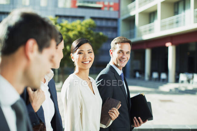 Pessoas de negócios sorridentes andando ao ar livre — Fotografia de Stock