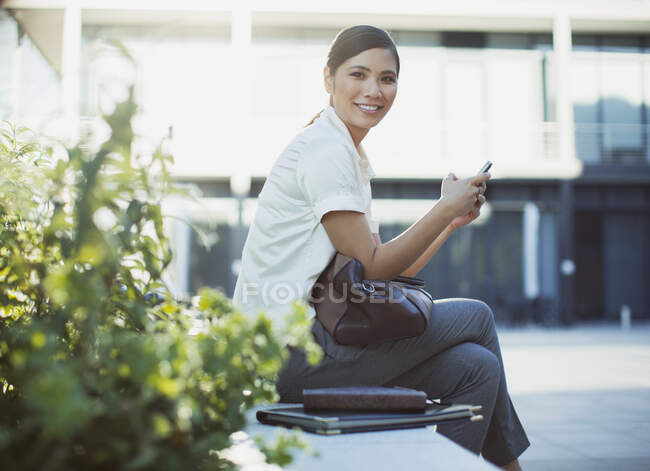 Messagerie texte femme d'affaires souriante à l'extérieur — Photo de stock