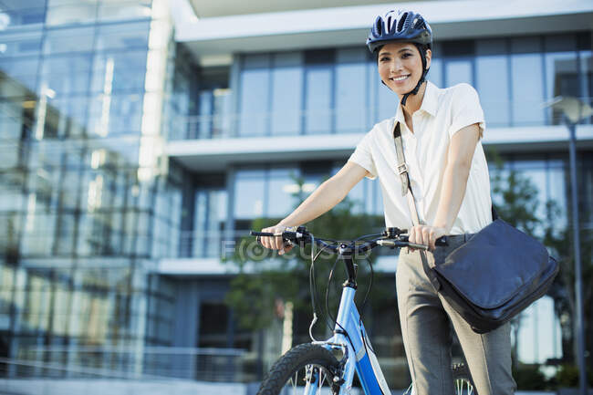 Businesswoman with bicycle outside urban building — Stock Photo