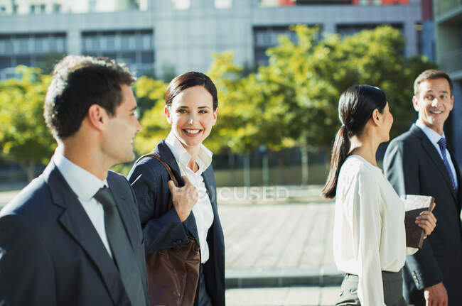 Smiling business people walking outdoors — Stock Photo