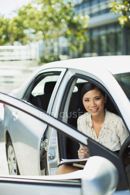 Sorridente donna d'affari seduta in auto — Foto stock