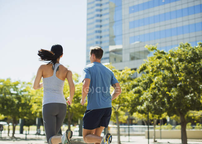 Couple jogging in urban park — Stock Photo