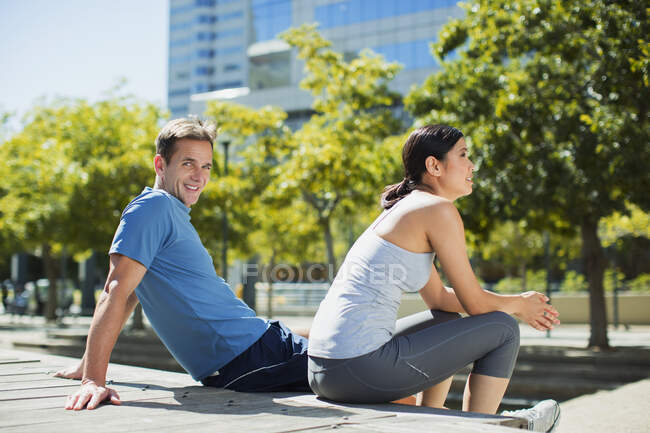 Homme souriant avec petite amie dans un parc urbain — Photo de stock