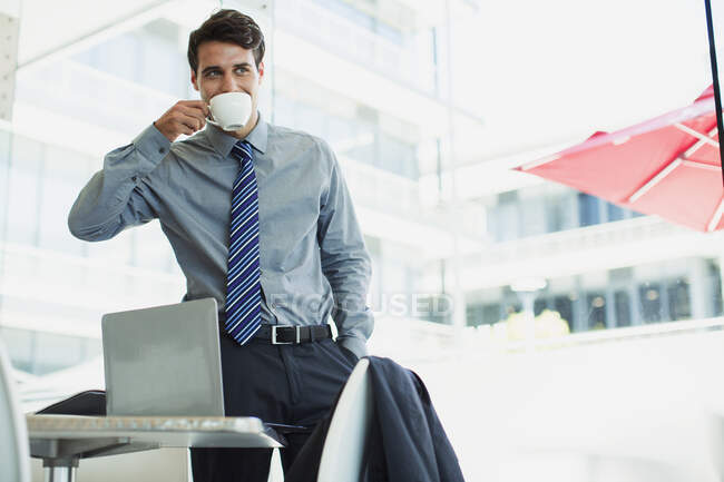 Businessman sipping coffee in office — Stock Photo