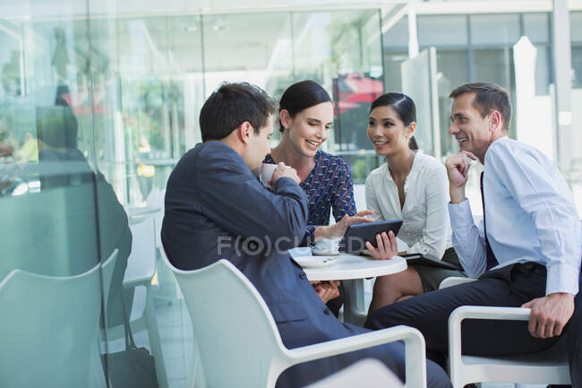 Business people using digital tablet at sidewalk cafe — Stock Photo