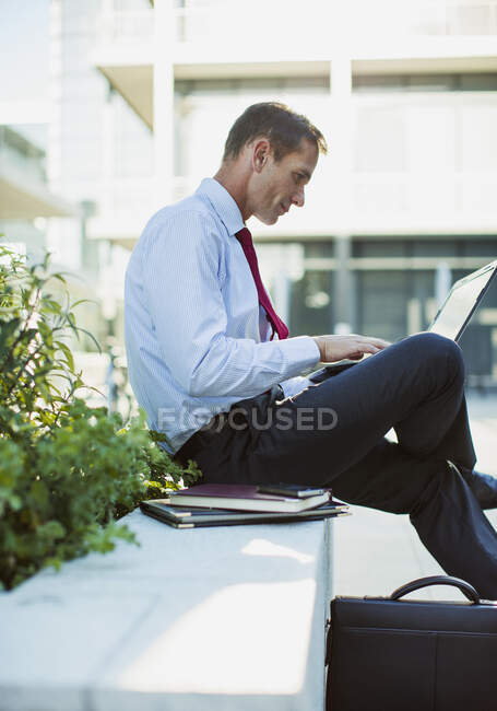 Empresario trabajando en el portátil al aire libre - foto de stock