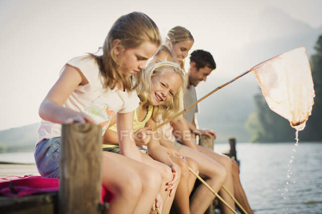 Família com redes de pesca na doca sobre lago — Fotografia de Stock