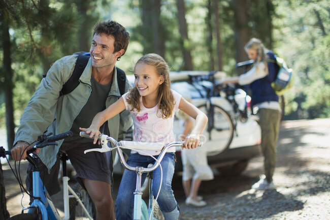 Father and daughter on bicycles in woods — Stock Photo