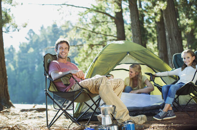 Lächelnde Familie entspannt auf dem Zeltplatz im Wald — Stockfoto