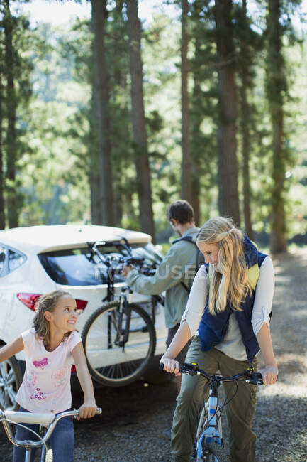 Famille heureuse avec des vélos dans les bois — Photo de stock