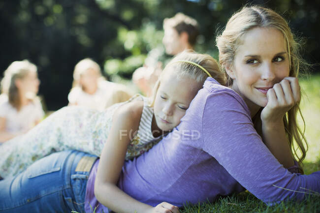 Безмятежные мать и дочь лежали в траве — стоковое фото