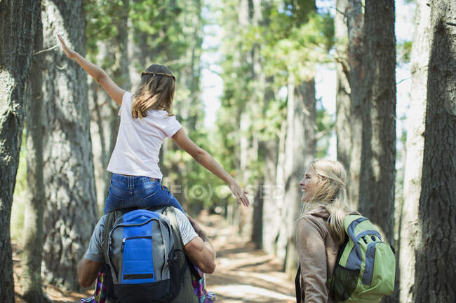 Отец носит дочь на плечах в лесу — стоковое фото