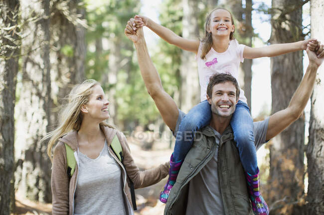 Padre llevando hija en hombros en el bosque - foto de stock