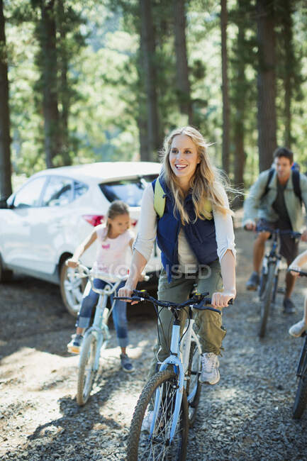Улыбающиеся семейные велосипеды в лесу — стоковое фото