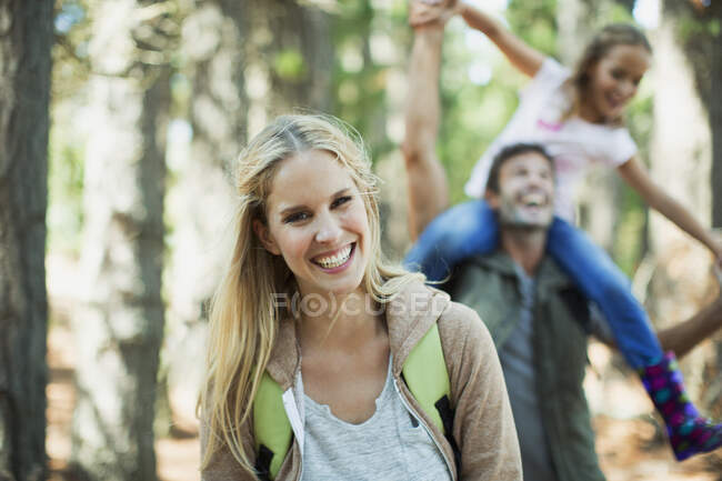 Улыбающаяся женщина с семьей в лесу — стоковое фото