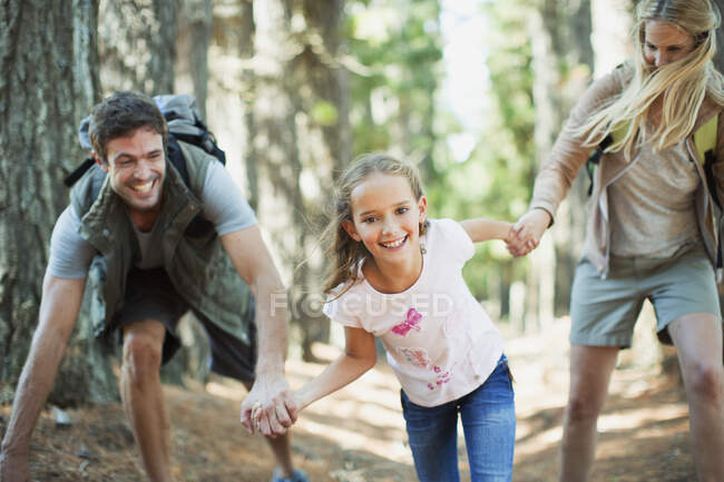 Семья держится за руки и бегает в лесу — стоковое фото